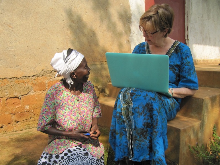  Karon speaking with Ugandan woman, recording survey data on an earlier trip.